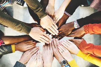 
Ръце на хора от различни етноси, образуващи кръг.