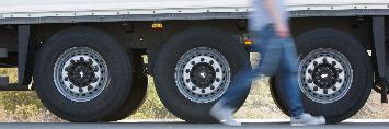 
A driver walks by the axles of his truck