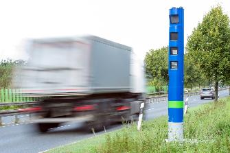 
A truck subject to toll passing an enforcement pillar