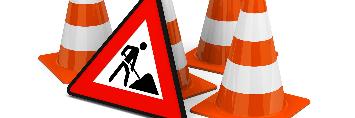 
Ein Verkehrszeichen „Baustelle“ steht neben einigen Warnkegeln.