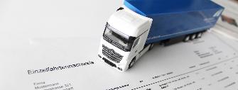 
A truck model stands on a printed itemised journey list