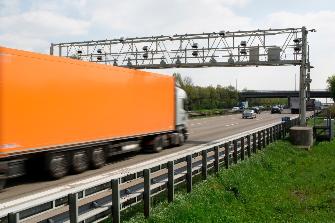 
Een vrachtwagen passeert een controlebrug op de autosnelweg