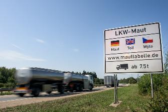 
Egy út mentén elhelyezett tábla felhívja a figyelmet a tehergépjárművek németországi útdíjfizetési kötelezettségére