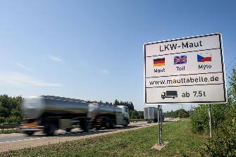 
Egy út mentén elhelyezett tábla felhívja a figyelmet a tehergépjárművek németországi útdíjfizetési kötelezettségére