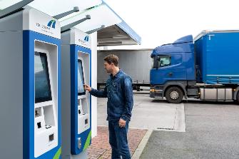 
A truck driver uses a toll terminal at a petrol station.
