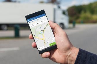 
One hand holds a smartphone with the screen showing the Toll Collect app.