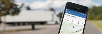 
Na displeji chytrého telefonu je vidět aplikace Toll Collect. V pozadí parkuje nákladní automobil.